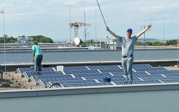Mitglieder der Energiegenossenschaft Erfurt reinigen die Solarmodule auf dem LKA in Erfurt